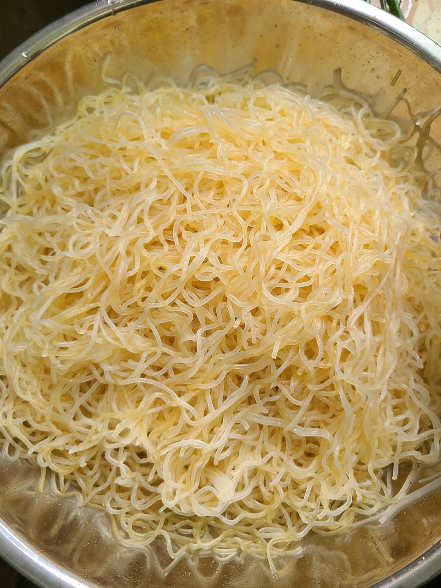 Spread the rice noodles evenly across a heatproof plate, and while you do this, set the steamer over the heat and bring the water to a boil.