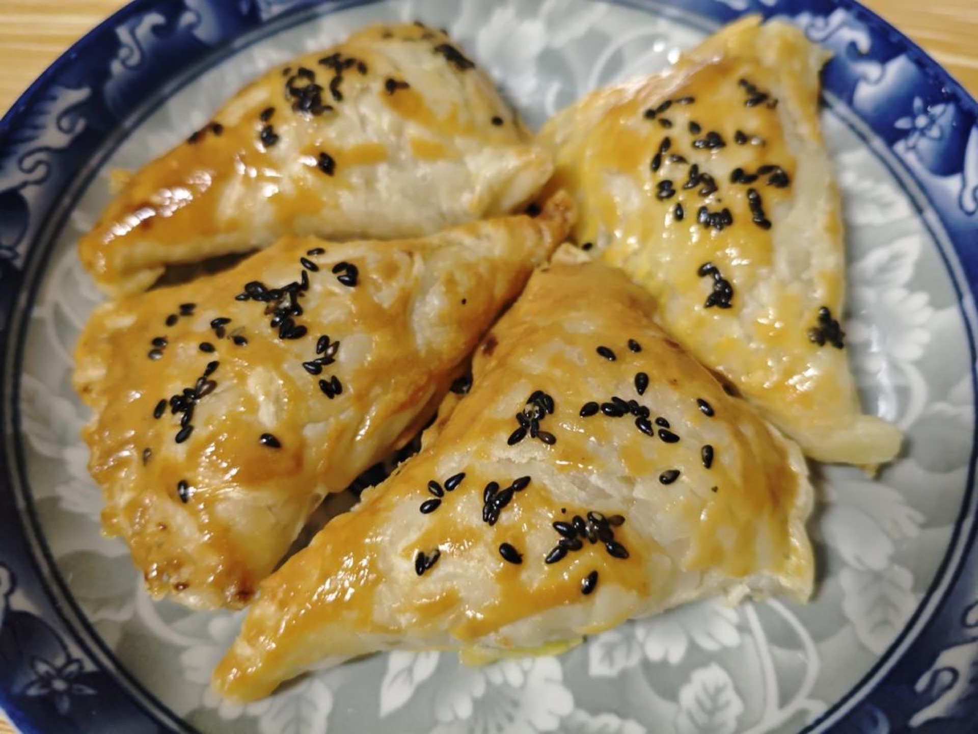 Air fryer apple pie hand pies on a plate with a crisp golden shell and sesame seeds