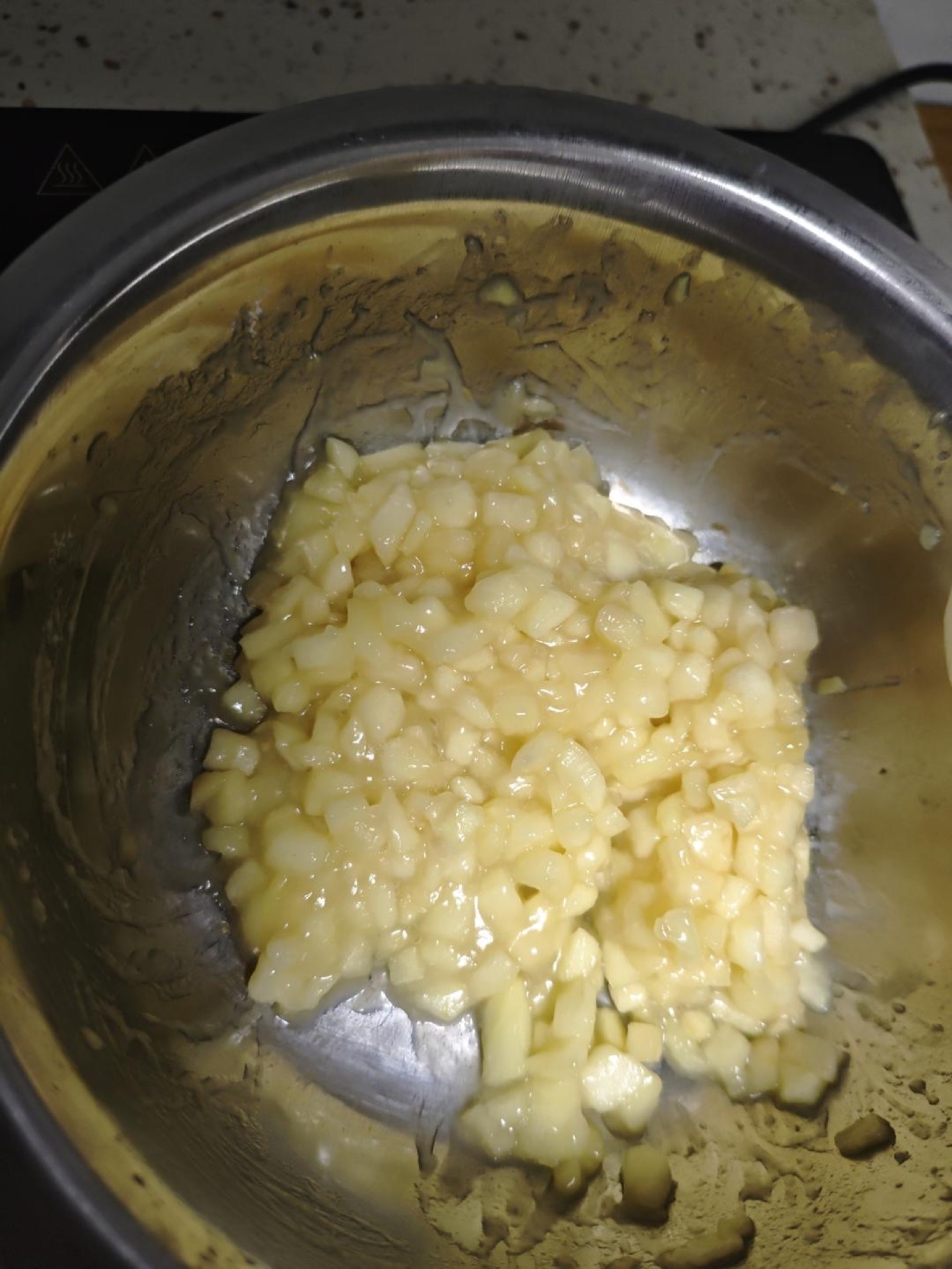 Cook the apple over low heat until it releases its liquid, add the condensed milk and sugar, keep cooking briefly, then pour in the cornstarch slurry (discarding the clear water on