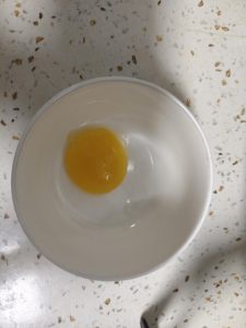 Crack one egg yolk into a bowl and beat it until loose.