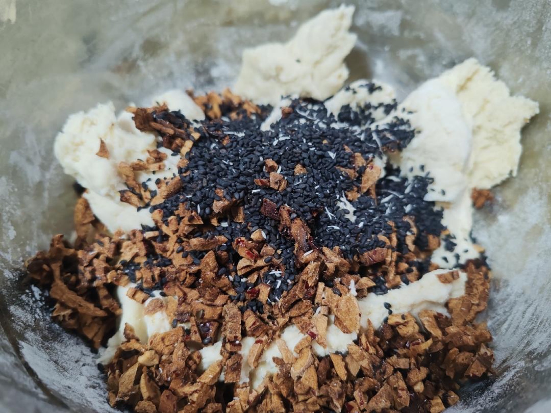 Add the chopped red dates and toasted sesame seeds to the dough and knead by hand until evenly distributed, which takes only a minute.