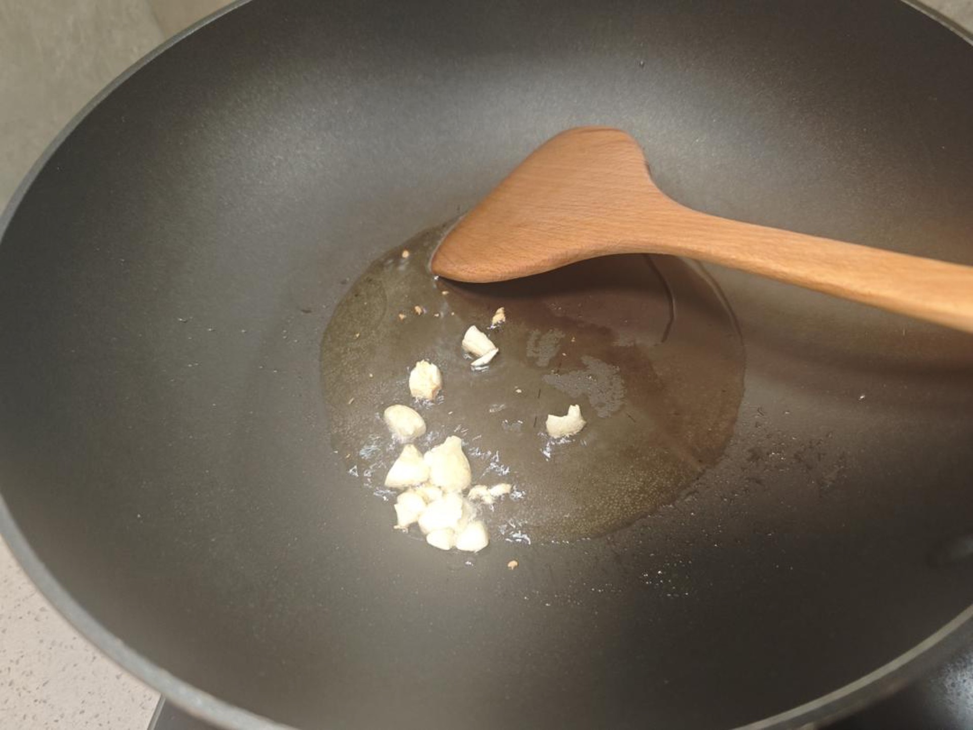 Set a wok over medium heat, add the oil, and once it shimmers add the smashed garlic, stirring for about 30 seconds until it smells sweet and fragrant but has not browned.