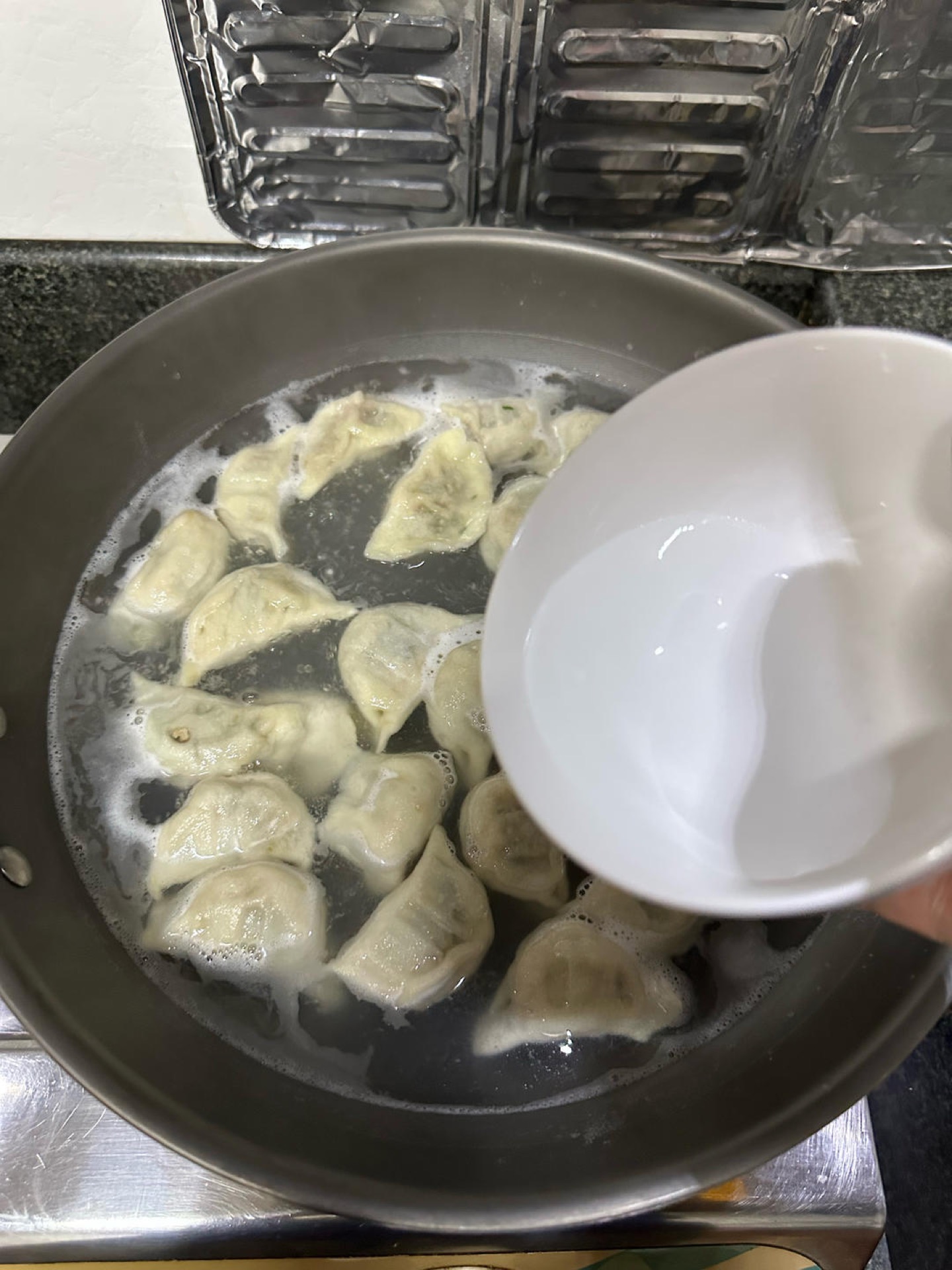 This is the step that makes the wrappers springy and cooks the filling through at the same time — a hard rolling boil cooks the skin to mush before the center is done. When the wat
