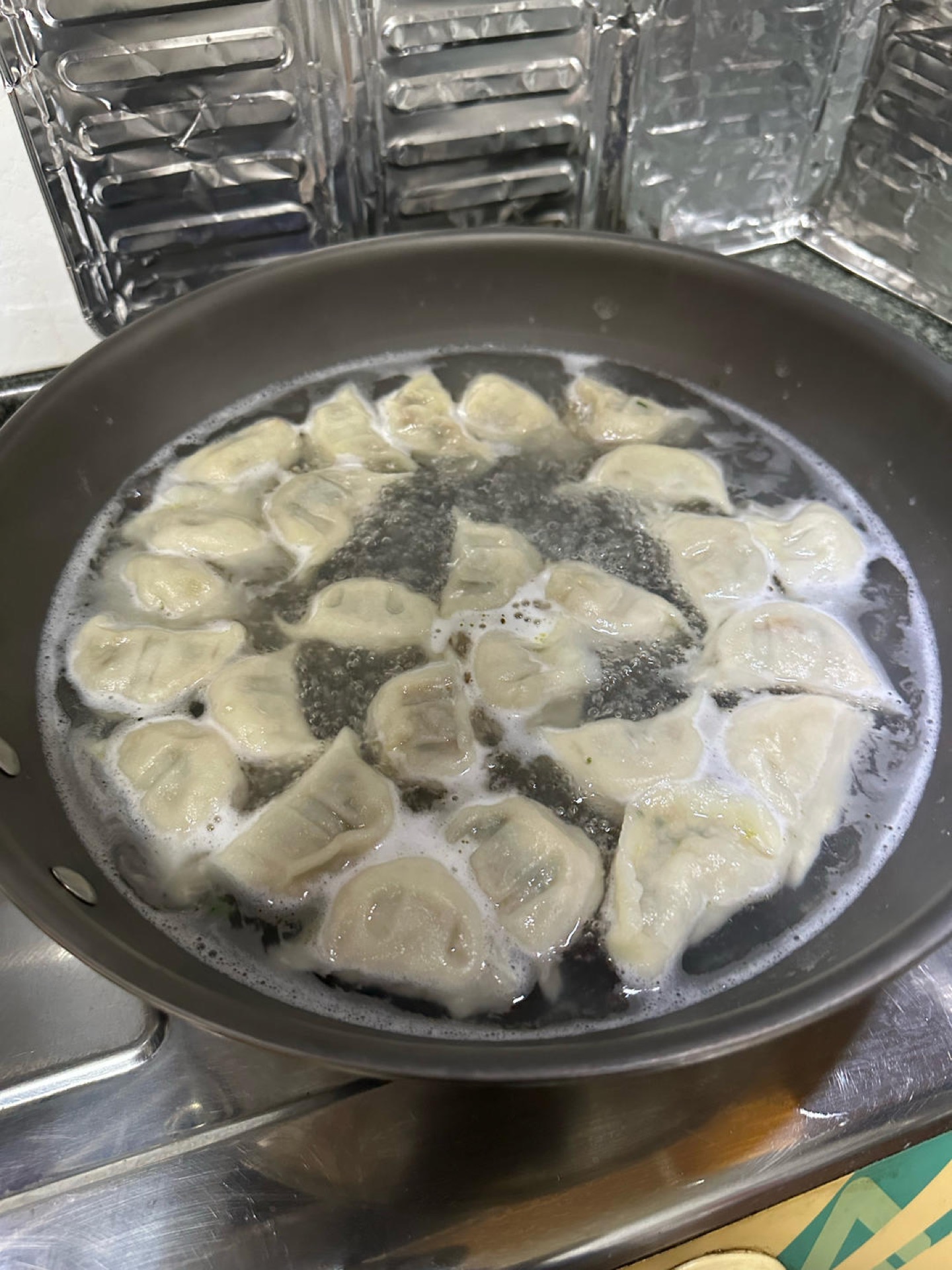 As soon as they're cooked, lift the dumplings out with a slotted spoon and let them drain briefly before plating — don't leave them sitting in the hot water. There's no need to rin