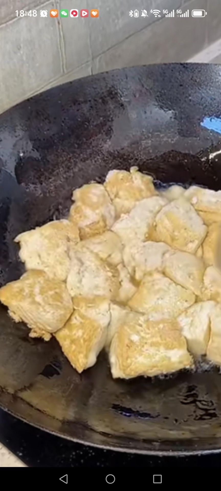 Heat a pan with oil, sprinkle in a little salt, and add the tofu, frying until both sides are golden brown as shown.