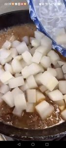 Add the drained daikon to the wok, season with a little salt and the chicken bouillon, and stir gently to combine.