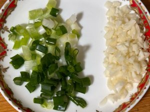 Finely chop the scallions, keeping the white parts and green parts separate, and mince the garlic.