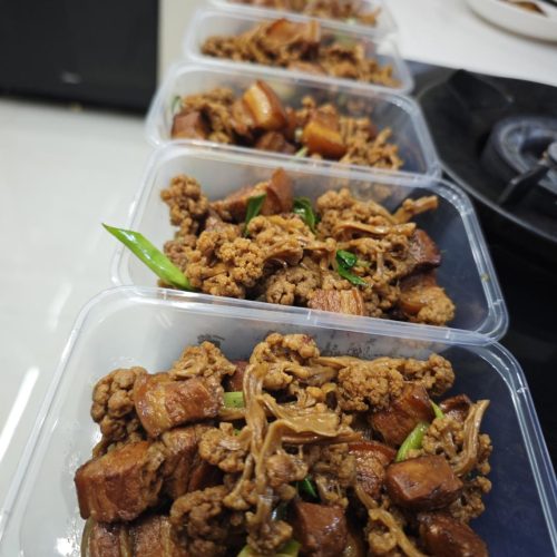 Braised pork belly with dried cauliflower in a dark sauce, finished with garlic sprouts