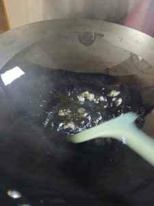 Heat the wok, add cool oil, and over low heat melt a small handful of rock sugar, then add the prepared pork and stir-fry quickly until every piece is evenly coated in color.