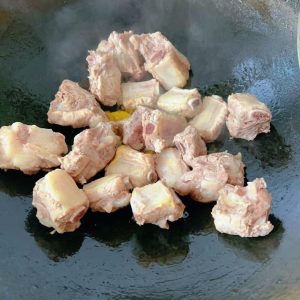Add the ribs to the wok and stir-fry to drive off the moisture.