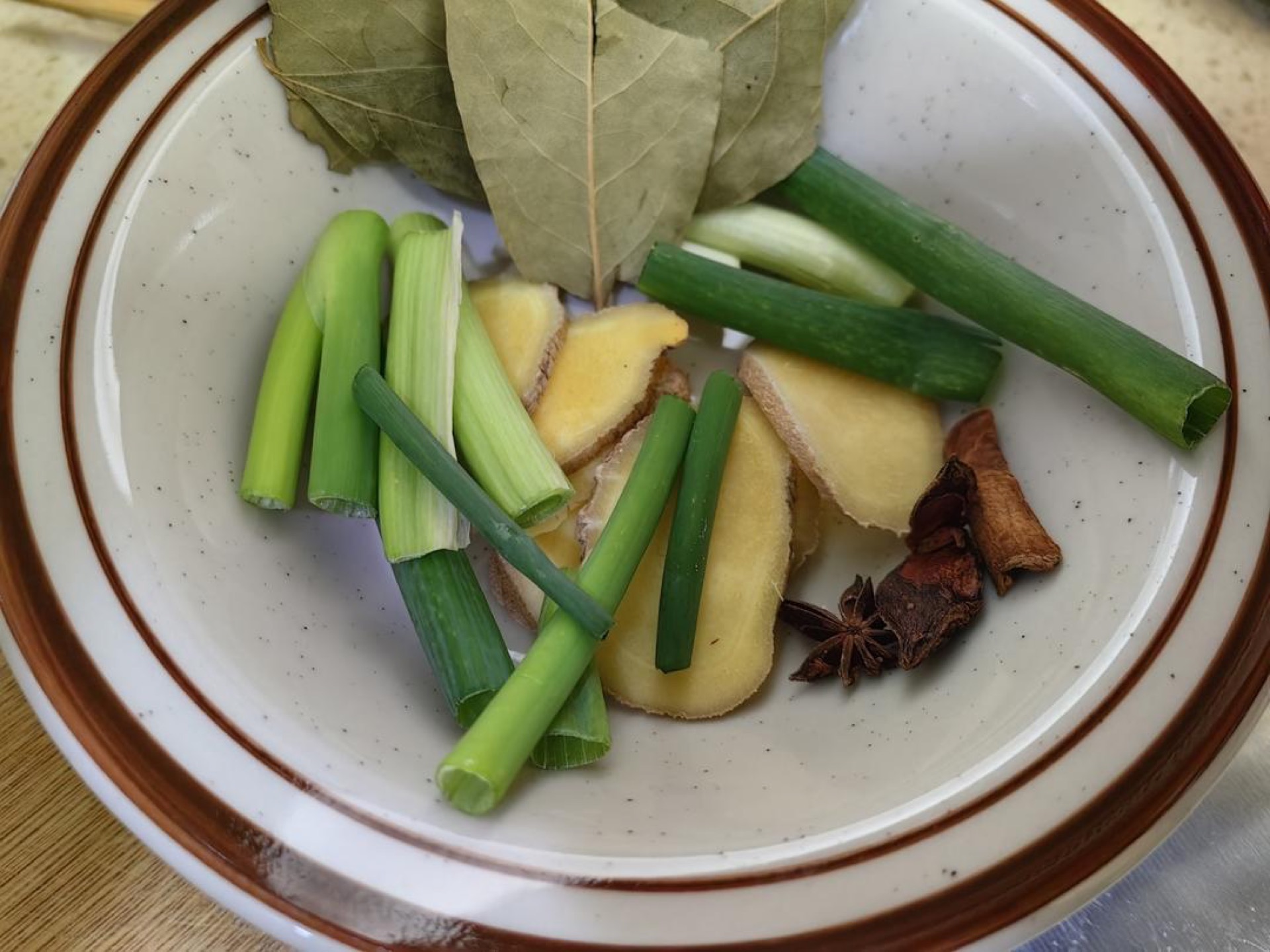 Prepare the aromatics: a whole scallion, extra ginger slices, one star anise, a small piece of cinnamon bark, several bay leaves, white peppercorns, and a generous pinch of white a