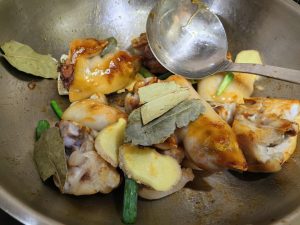 Add the blanched trotters to the wok and toss to coat them evenly in the caramel until they take on a deep amber color, then add all the aromatics.