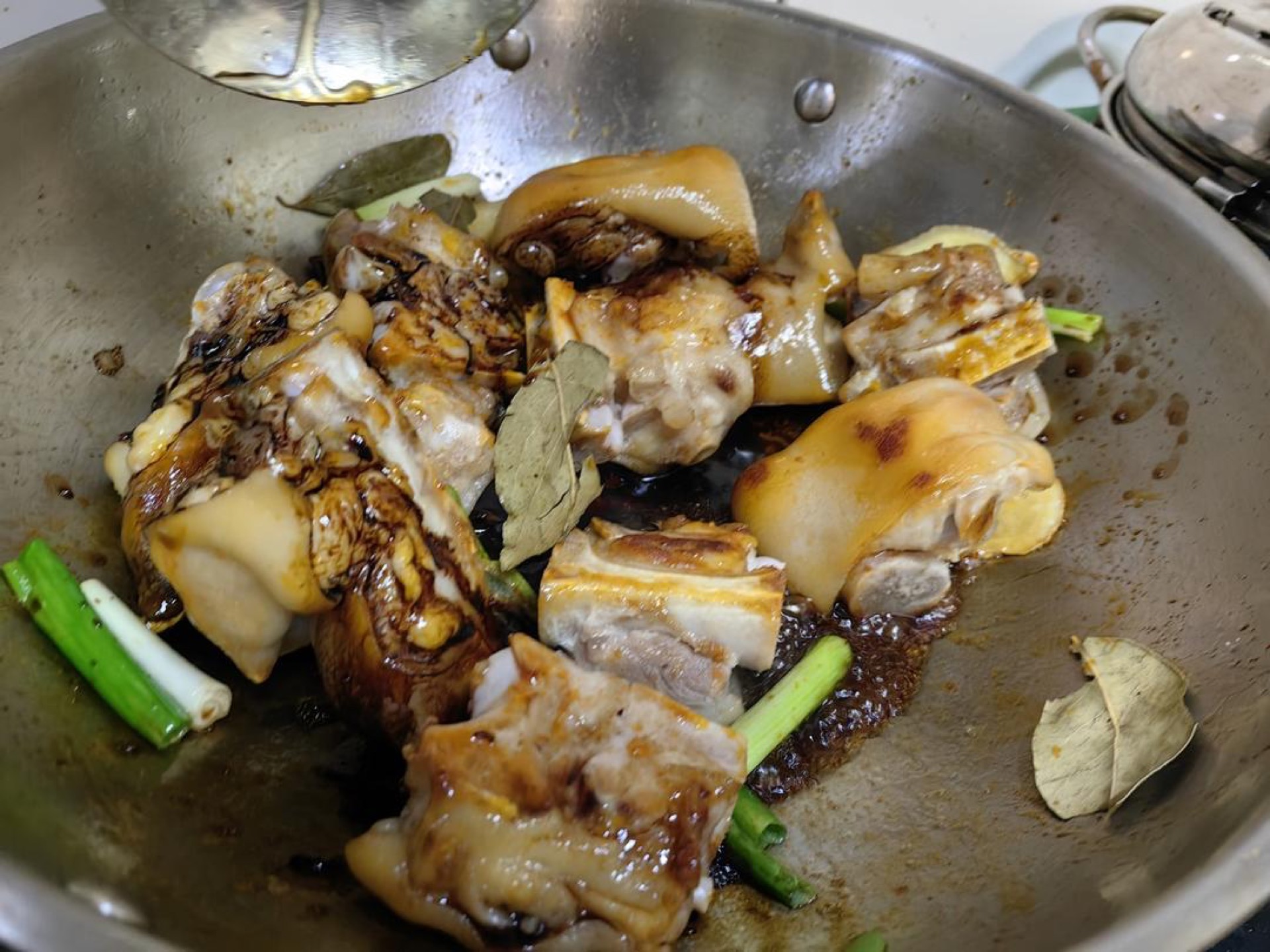 Pour in the light soy sauce and dark soy sauce, stirring to coat the trotters evenly.