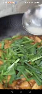 Add the garlic chives and drizzle in the cornstarch slurry, stirring so the sauce thickens around the tofu and the chives just wilt.