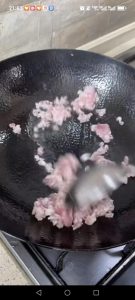 Start a second clean wok over medium-high heat, add a little oil, and add the ground pork, breaking it apart and stir-frying until it is crumbly and fragrant.