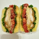 Cheese-stuffed chicken cutlet sandwich cut in half showing molten cheese flowing out