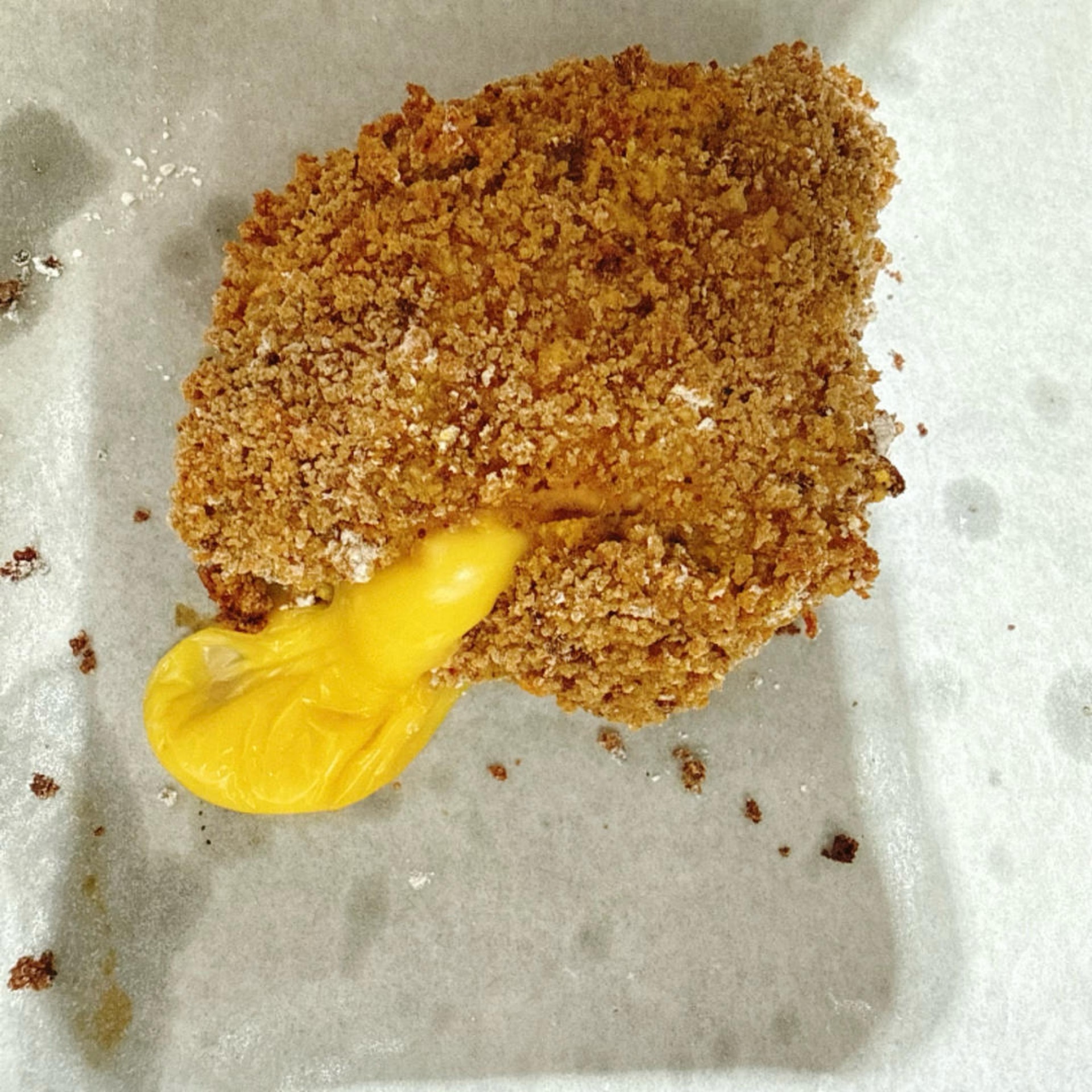 The cheese playfully peeks out from the cutlet as it bakes.