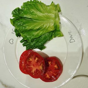 Prepare all the sandwich ingredients: toasted bread, lettuce, tomato slices, ketchup, and the baked chicken cutlets.