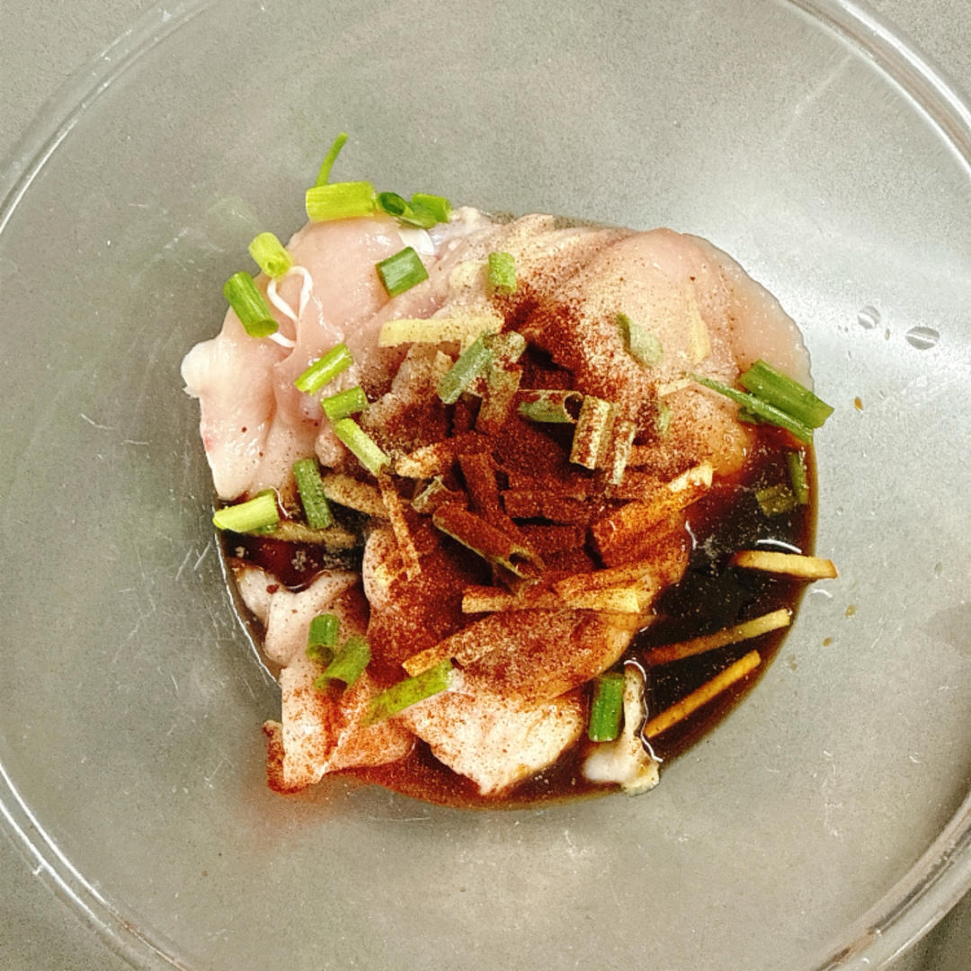 Add chopped scallion, julienned ginger, soy sauce, Shaoxing wine, salt, black pepper, and paprika to the chicken.