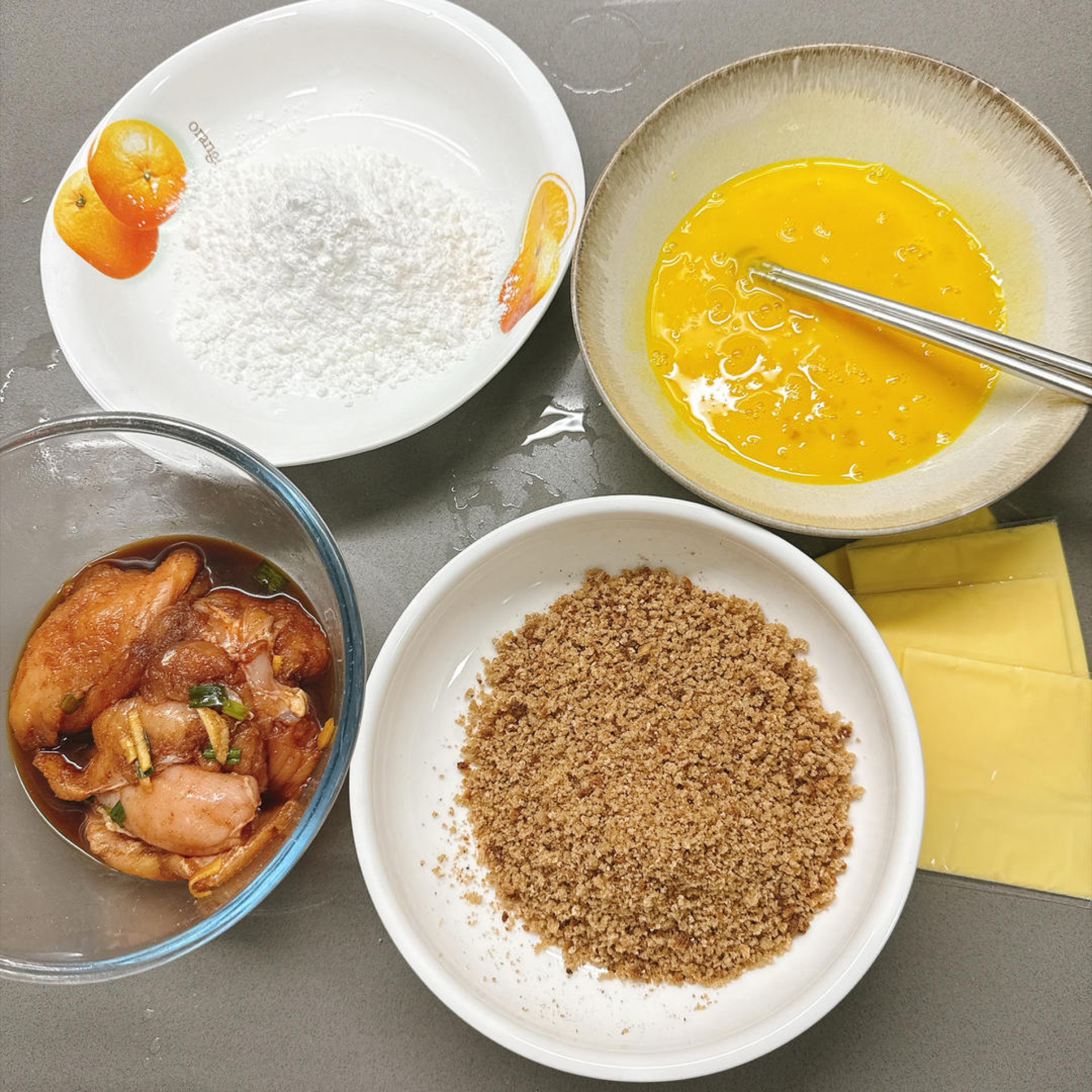 Gather the ingredients for breading the chicken cutlets; the breadcrumbs used here are made from crushed whole wheat artisan bread for a healthier, additive-free coating.