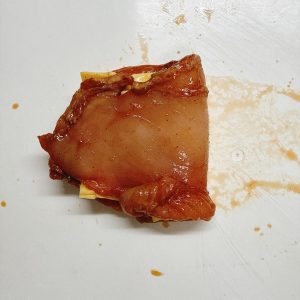 Close the chicken over the cheese; note that sealing it this way may cause the cheese to leak, so folding the cheese in half inside helps contain it.