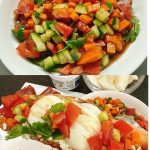 Chopped vegetable salad with diced tomato, carrot, cucumber, and cilantro in a clear glass bowl