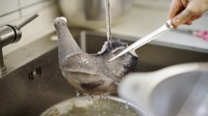 Blanch in cold water over medium-low heat for about 20 minutes — it does not need to come to a full boil — then rinse clean under hot water.