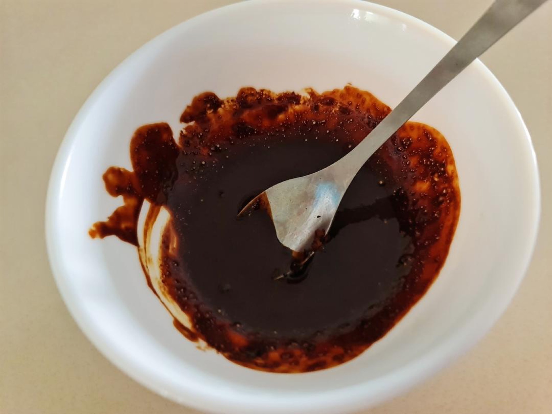 Microwave 20 g of milk until warm, pour it over the instant coffee powder, and stir until the coffee dissolves completely.