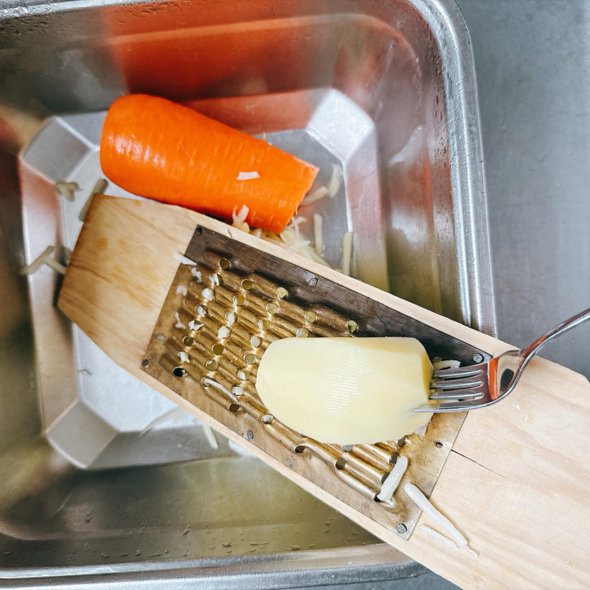 Grate the potato and carrot directly into a large bowl using the coarse side of a box grater.