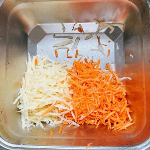 Leave the grated potato and carrot together in the bowl without rinsing them.