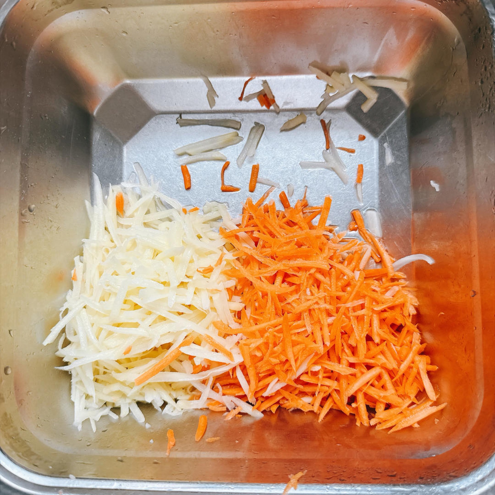 Leave the grated potato and carrot together in the bowl without rinsing them.