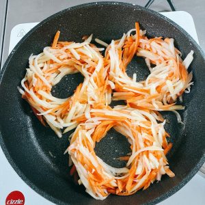 Brush the wok with oil, then gather the potato and carrot shreds into nest shapes with a hole in the middle.