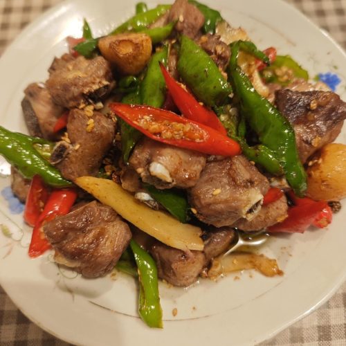 Double pepper pork ribs with green and red chilies in a wok