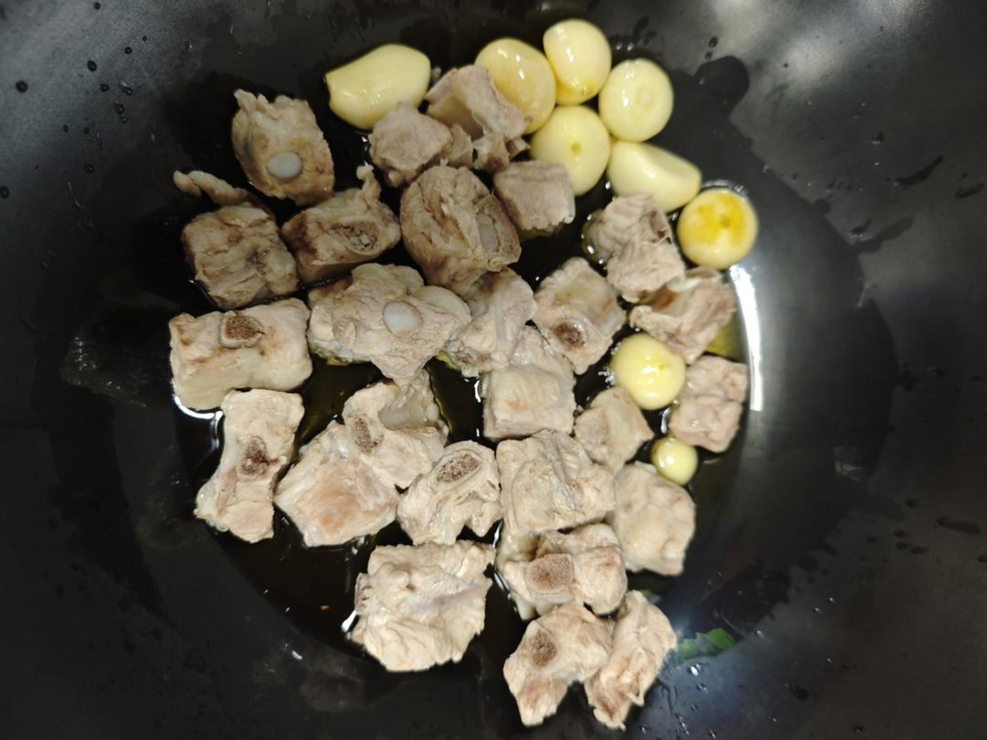 Heat oil in the wok and add the garlic, frying it along with the ribs.