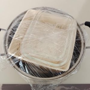 Set two glass boxes without their lids on top of the tofu draining box so the weight presses the water out of the tofu.
