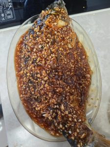 Lift the fish out onto a serving plate and spread the mixed garlic sauce evenly over the whole body.