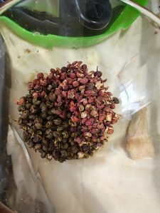 Heat oil in a wok, add the green and red Sichuan peppercorns and the chili shreds, fry until they change color, then pour the hot oil over the sauce on the fish.
