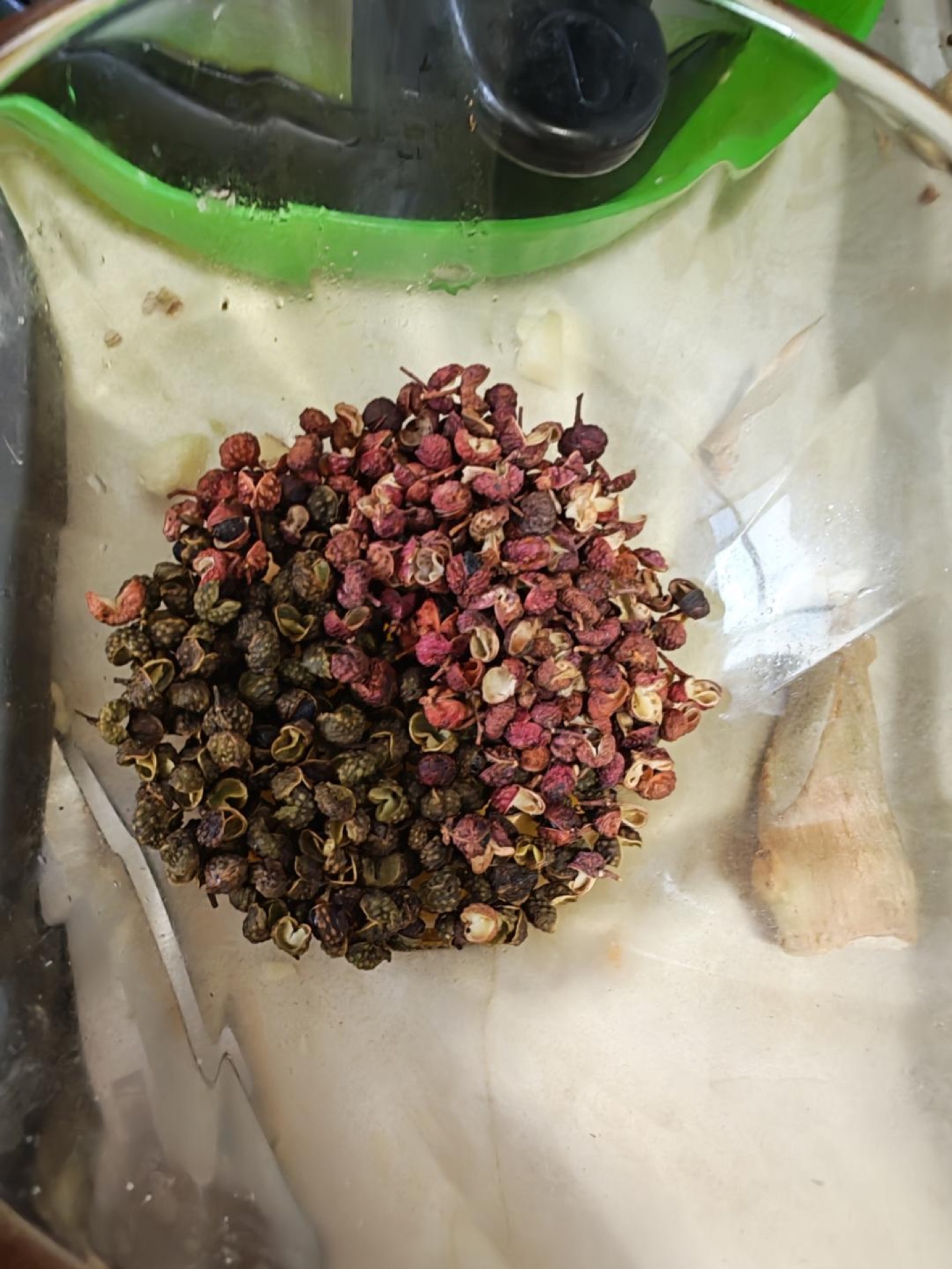 Heat oil in a wok, add the green and red Sichuan peppercorns and the chili shreds, fry until they change color, then pour the hot oil over the sauce on the fish.