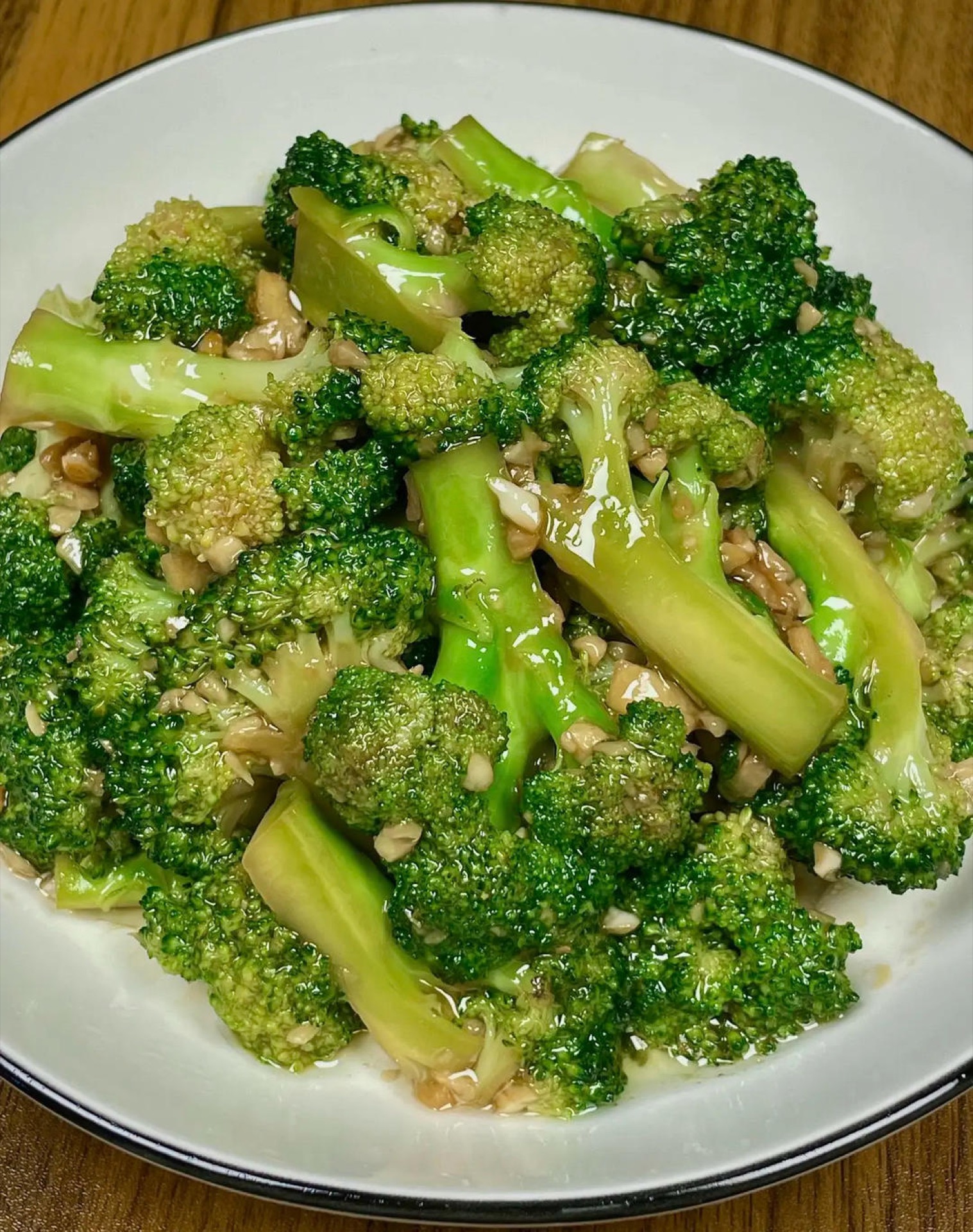 Garlic oyster sauce broccoli on a white plate, glossy green florets coated in savory sauce
