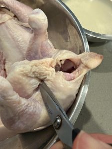 Use kitchen scissors to poke one small hole through the skin on each side near the tail.