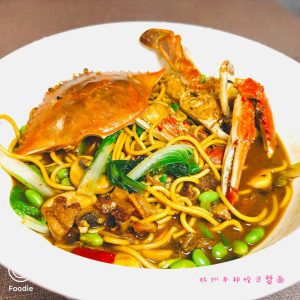 Hangzhou swimming crab noodles served in a bowl with crab pieces, edamame and greens