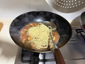 Add the noodles to the wok and cook over the highest heat for 90 seconds — that is enough.