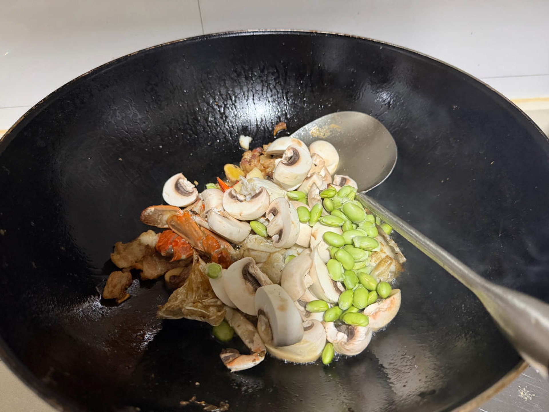 Add the edamame and mushrooms and stir-fry. Fresh bamboo shoots would be even better here; since whip bamboo has finished and winter bamboo has not arrived, there are no good shoot