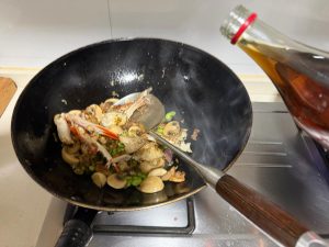Pour the Shaoxing wine in a circle around the rim of the wok.