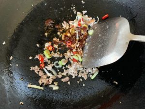 Heat the oil in a wok over medium-high heat, add the ground chicken, and stir-fry until it is just cooked through. Add the leek and red chili and stir until fragrant, then add a sp