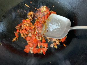 Add the tomato and sugar and stir-fry until the tomato releases its juices, then pour in the soy sauce and stir to combine.