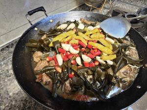 Add the kelp, garlic, small chili peppers, and pickled chilies, cover, and simmer for 20 minutes without stirring them in evenly — just lay them on the surface, cover, and let them