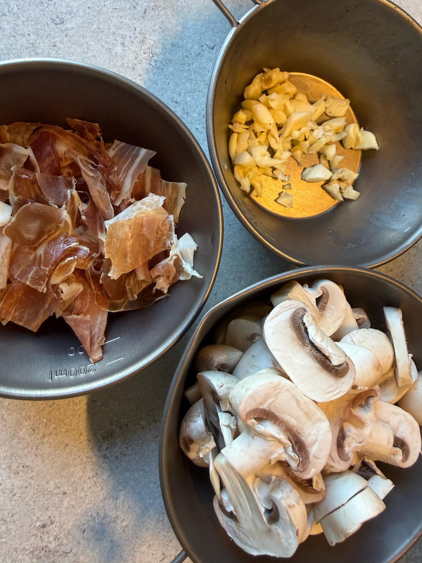 Rinse and slice the button mushrooms, snip the Parma ham into small pieces, and finely mince the garlic.