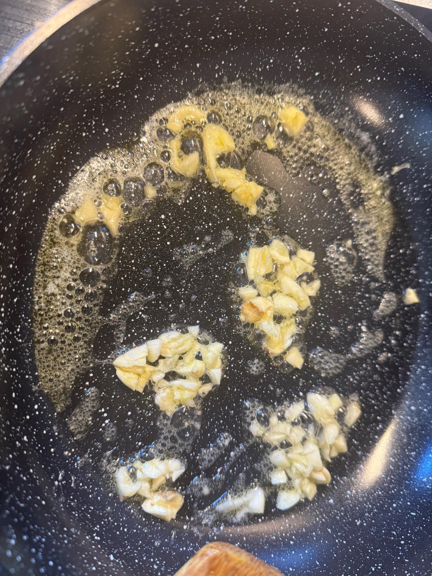 Heat the wok over medium heat until the butter melts, then add the minced garlic and stir until fragrant.