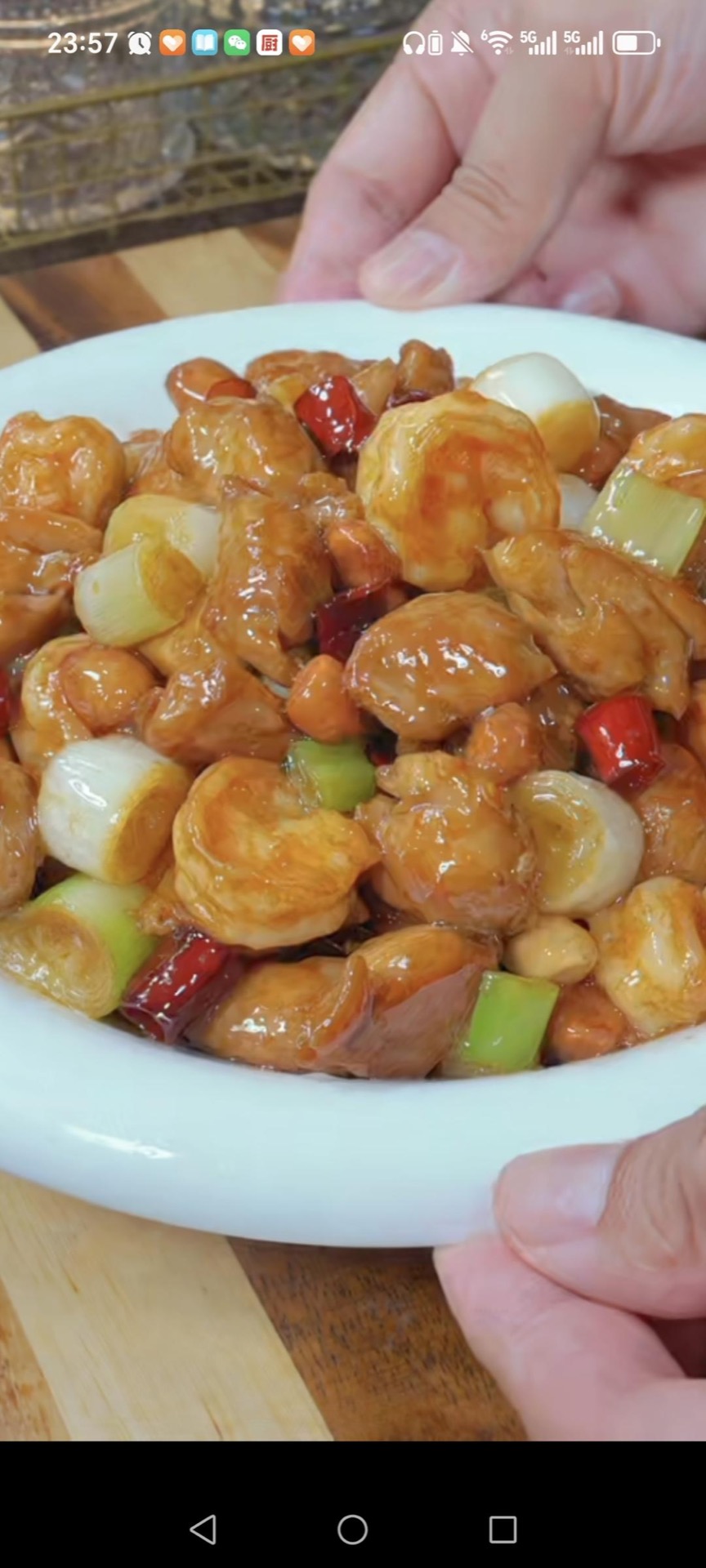 Kung Pao chicken with shrimp balls in a wok with peanuts and dried chilies